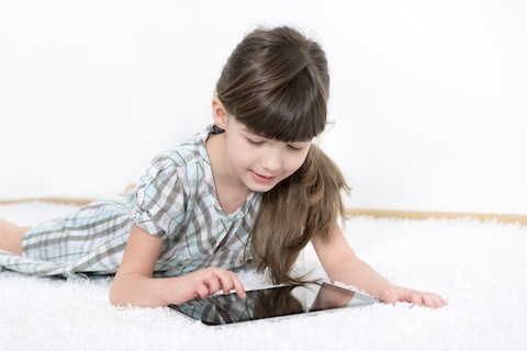 väike tüdruk, kes mängib tahvelarvutiga