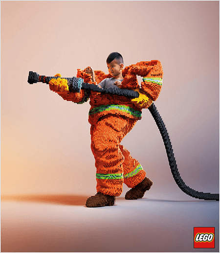 See on foto LEGO kuulutusest, millel on kujutatud LEGOdest valmistatud tuletõrjuja vormis noort Aasia poissi. Vorm on oranž ja neooni rohelise triibuga mantli ja pükste mansettide ümber. Tuletõrjuja seisab ühe jala seljaga ja hoiab käes ka legodest valmistatud tuletõrjevoolikut. Poisi pea paistab vormi ülaosast välja, mis on palju suurem kui tema ja peatub ümber õlgade. Foto on tehtud tavalisel neutraalsel taustal. LEGO logo ilmub paremas alanurgas punasesse kasti. Talia Wolfi sõnul on LEGO suurepärane näide brändist, mis kasutab reklaamis emotsioone.